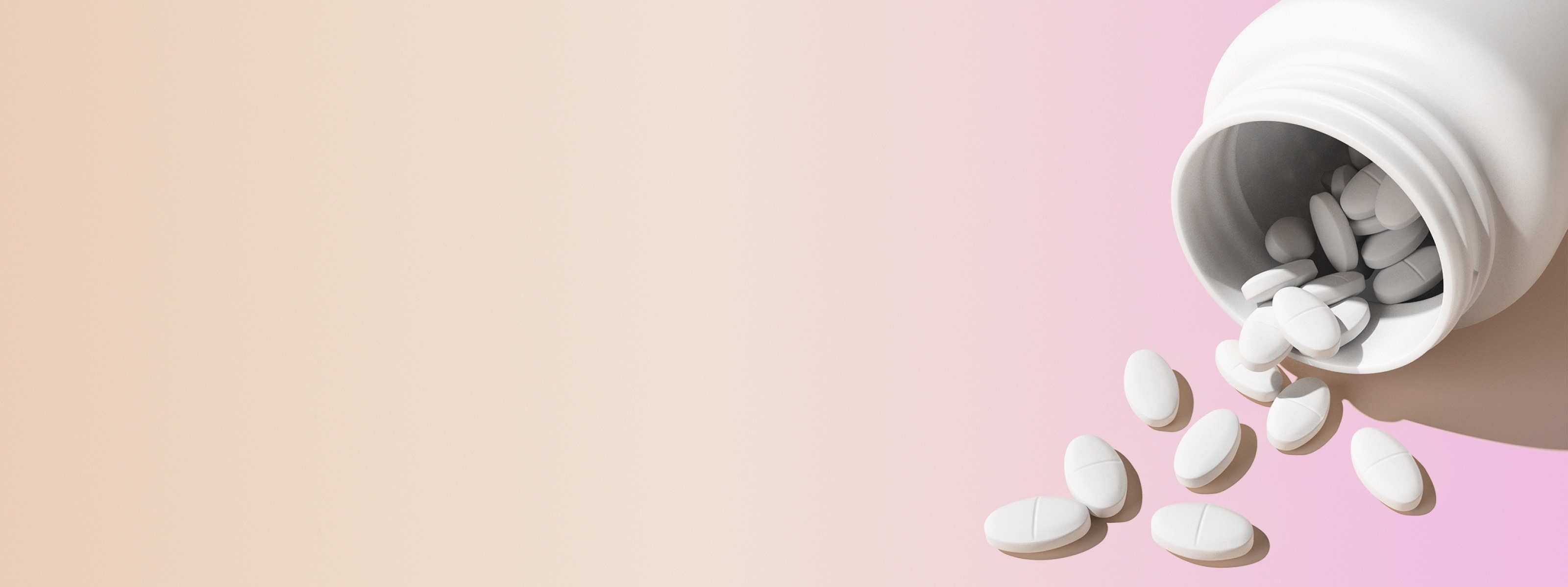 a tipped over white pill bottle with norethindrone tablets spilling out in front of a beige and pink background