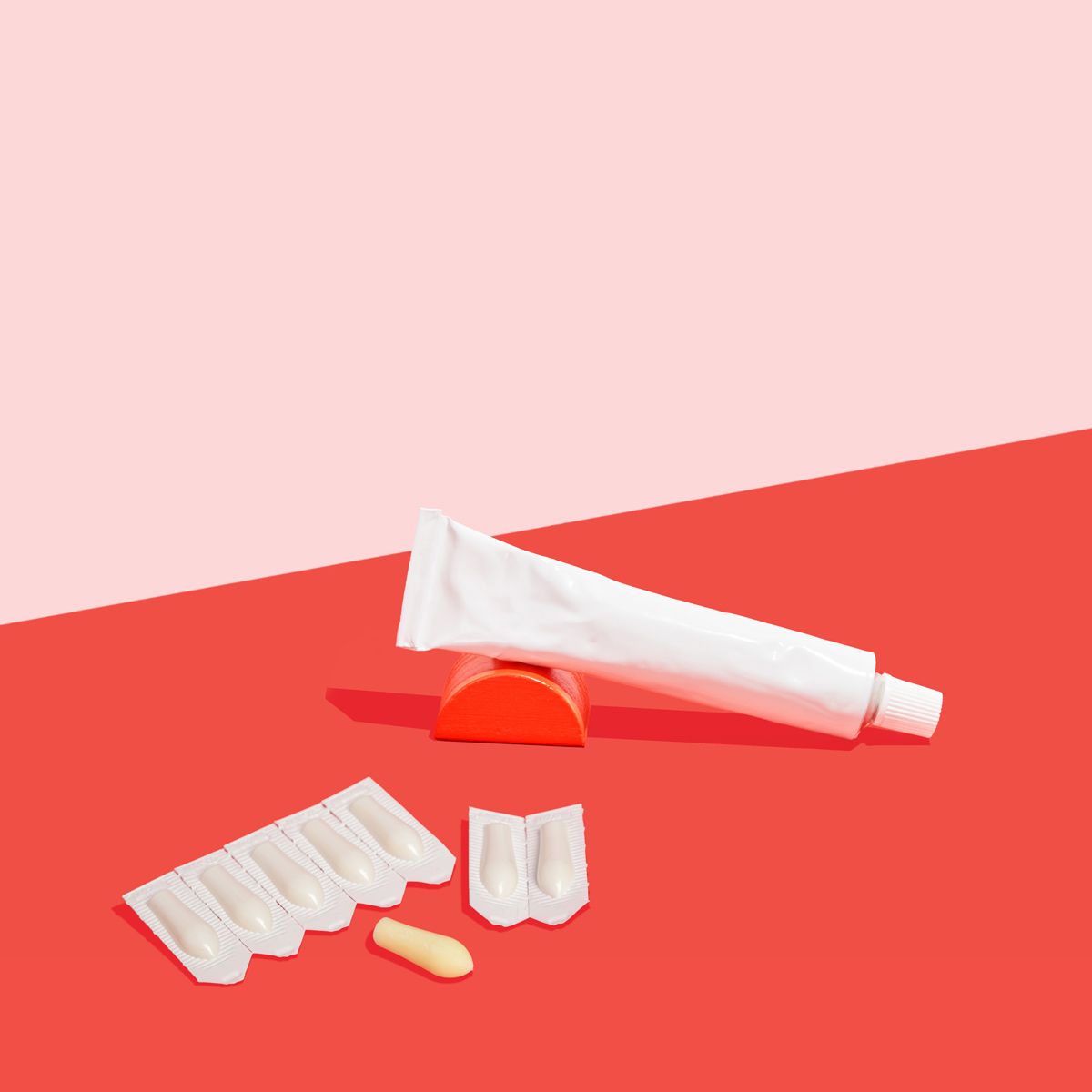 Topical and suppository hemorrhoid treatment on a pink and red background
