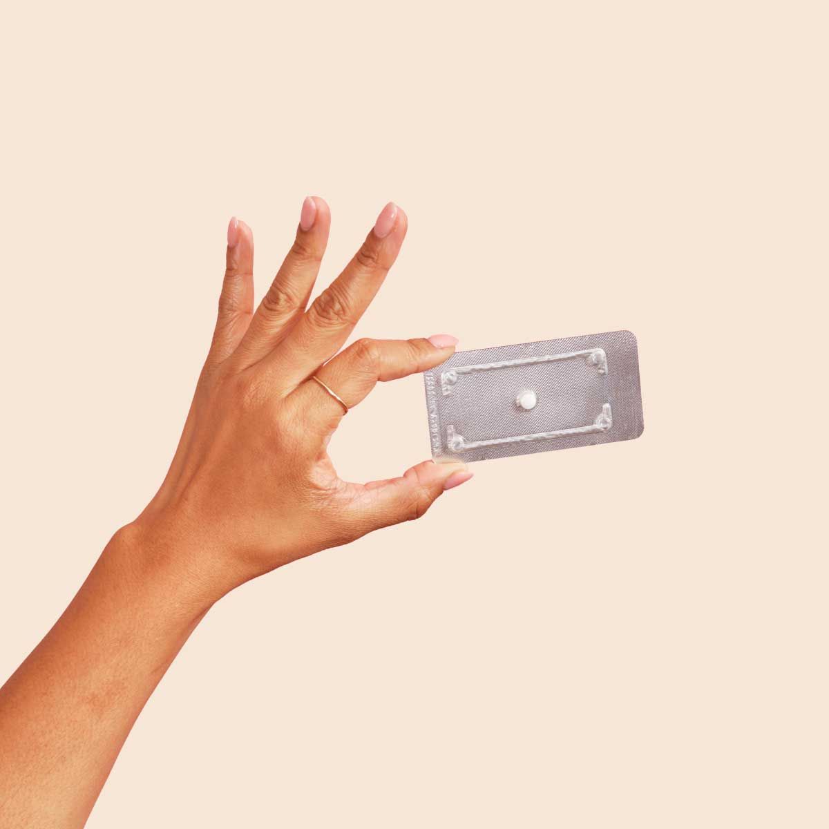 A person's hand holding Levonorgestrel (Generic PLAN B®) emergency contraception