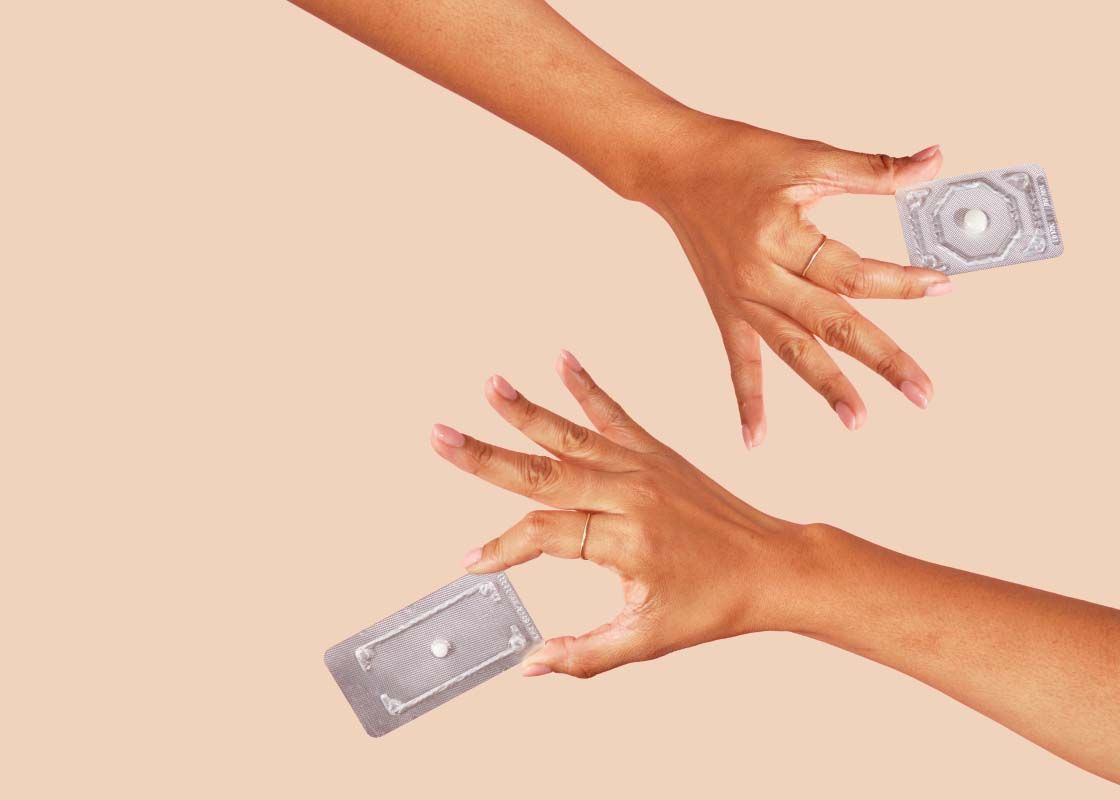 hands holding Plan B and Ella emergency contraception on a cream background
