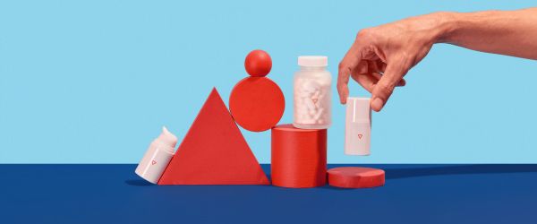 a man's hand reaches for Wisp prescription Genital Herpes treatment and prevention on a blue and red geometric background