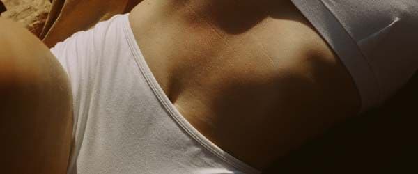A close up of a woman's abdomen while laying on a bed