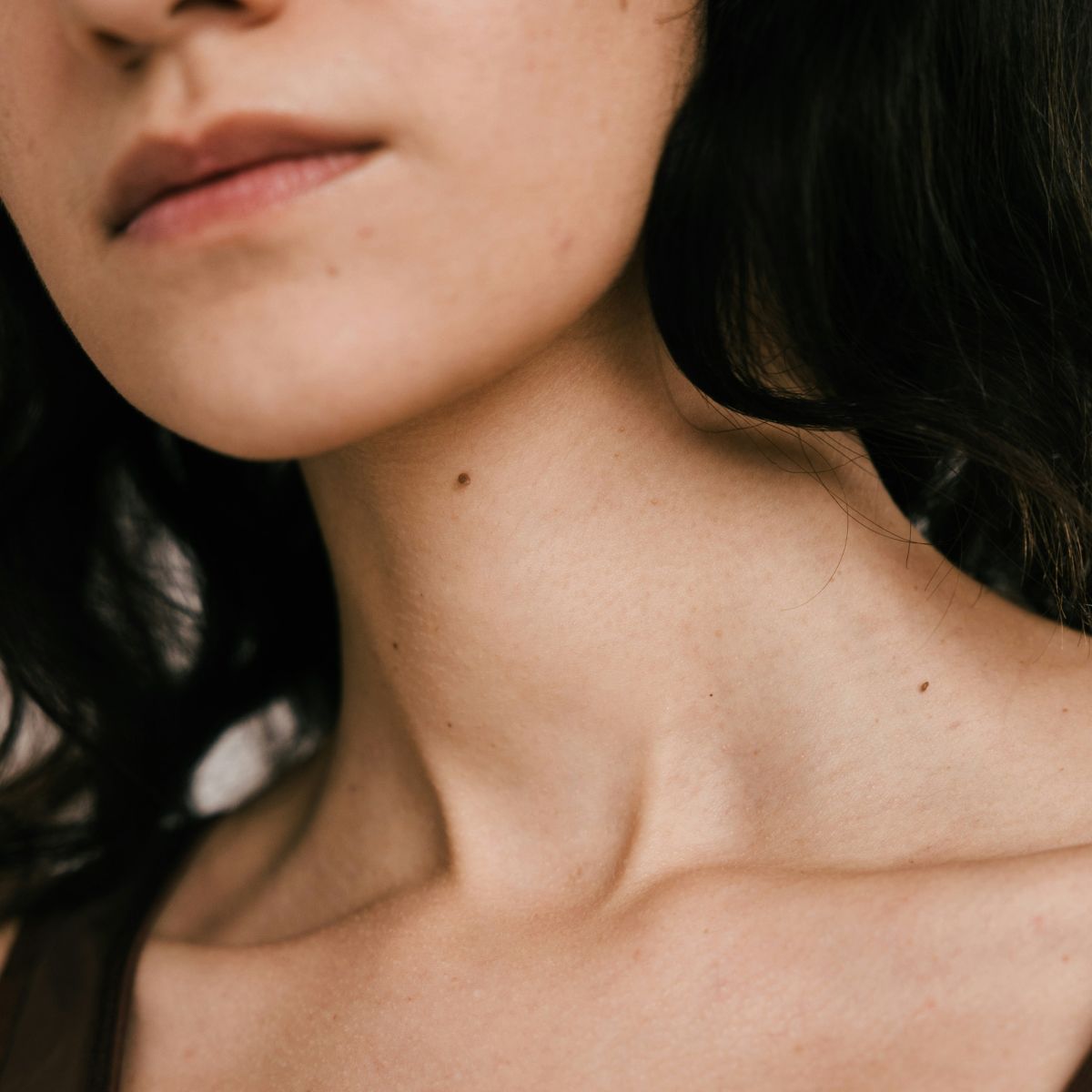 A close up of a woman with dark hair and a neutral expression