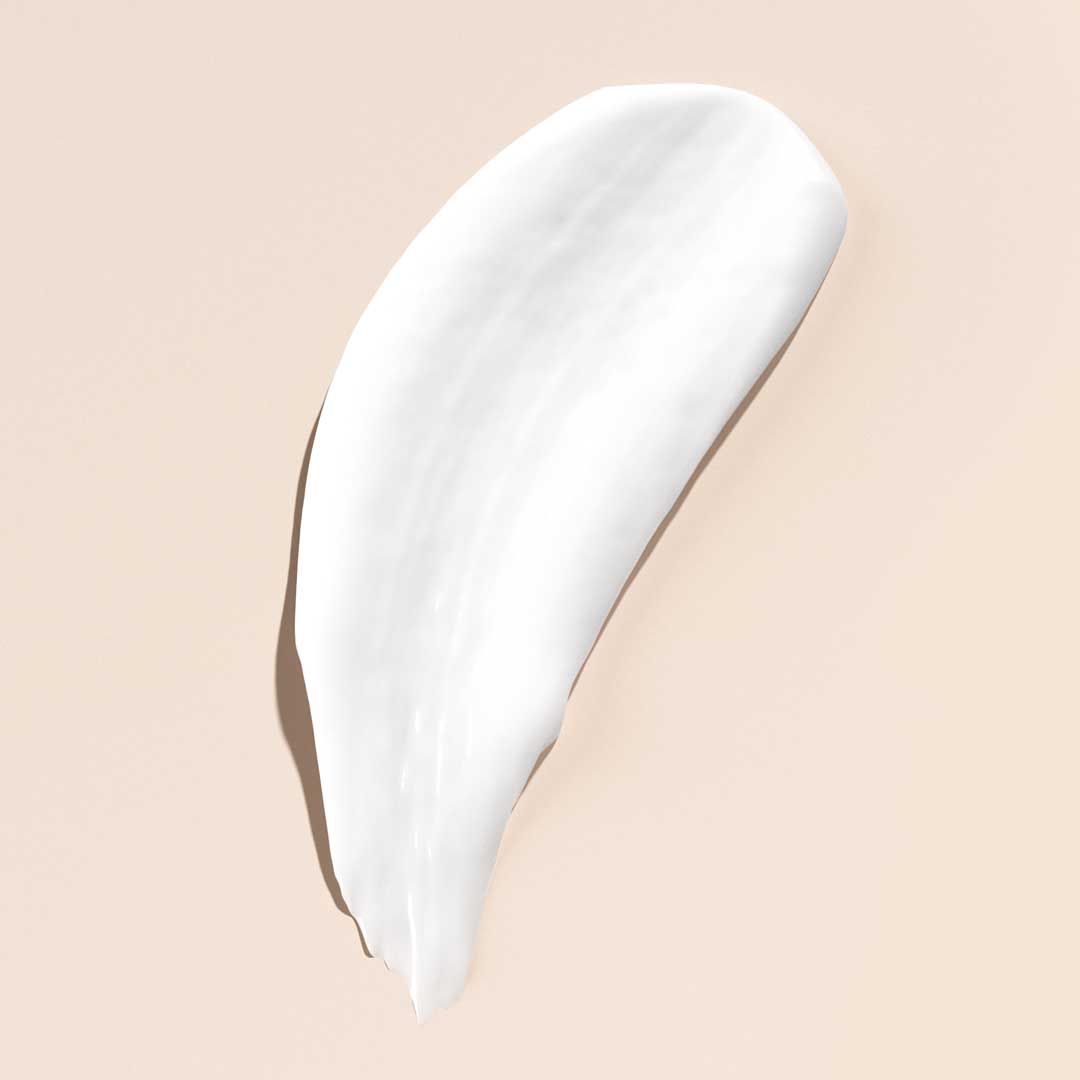 A white cream swatch on a cream surface