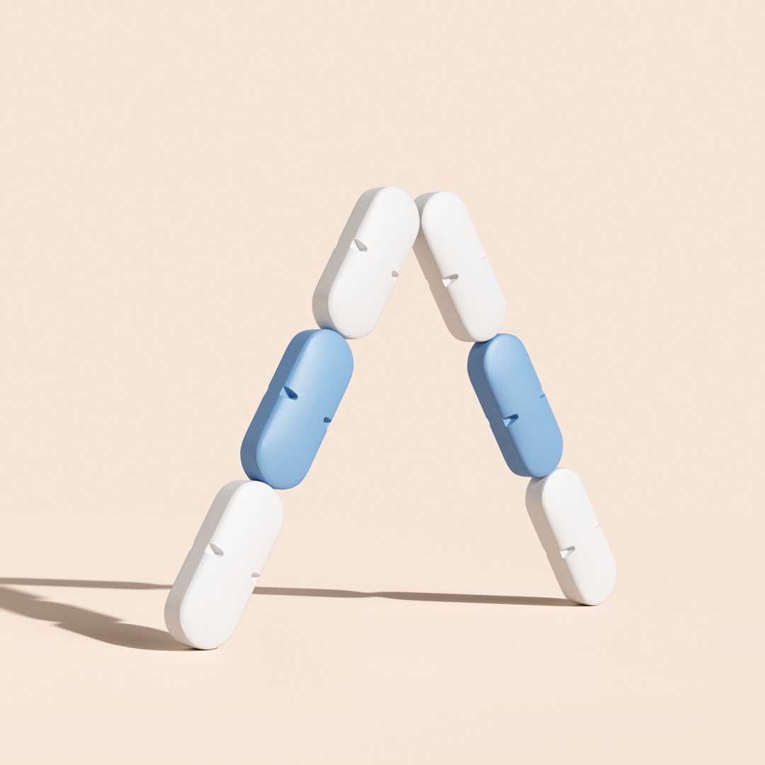 Blue and white pills arranged in a trangle on a cream surface