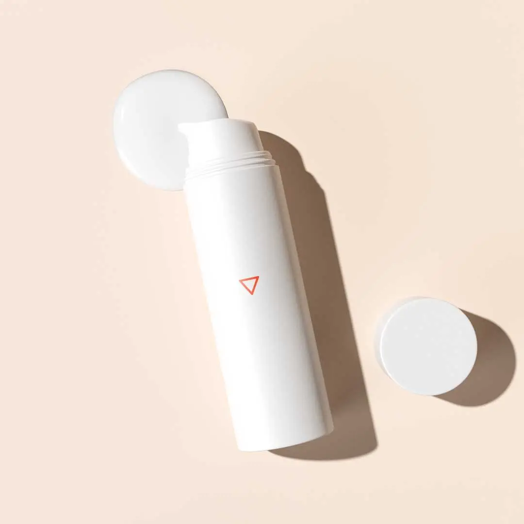 A bottle of Topical Spironolactone with a cream swatch on a beige surface