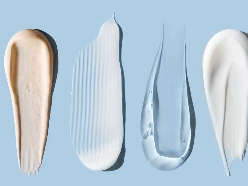 Skincare cream and gel swatches on a light blue surface