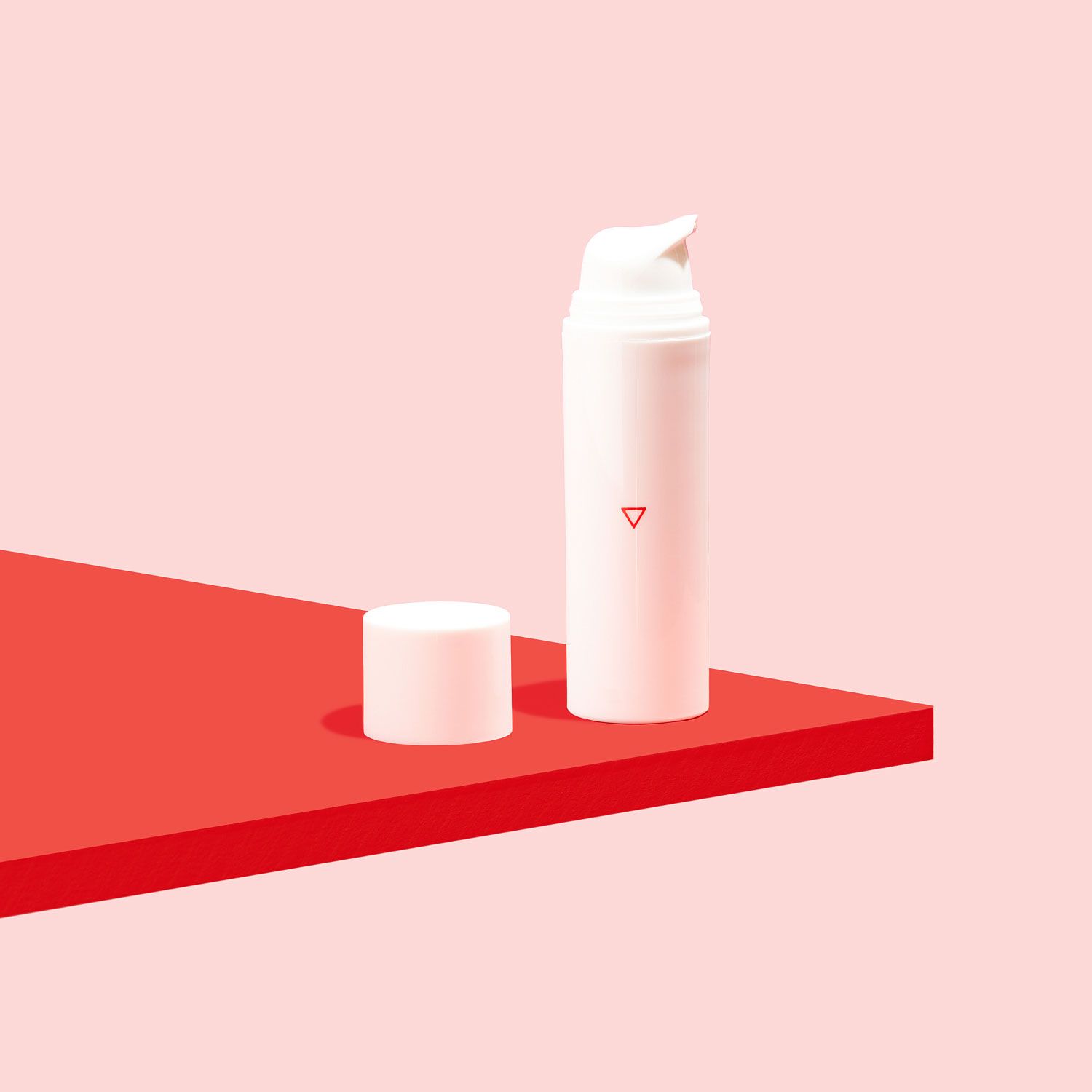 A bottle of Topical Spironolactone is sitting on a red surface with a pink background