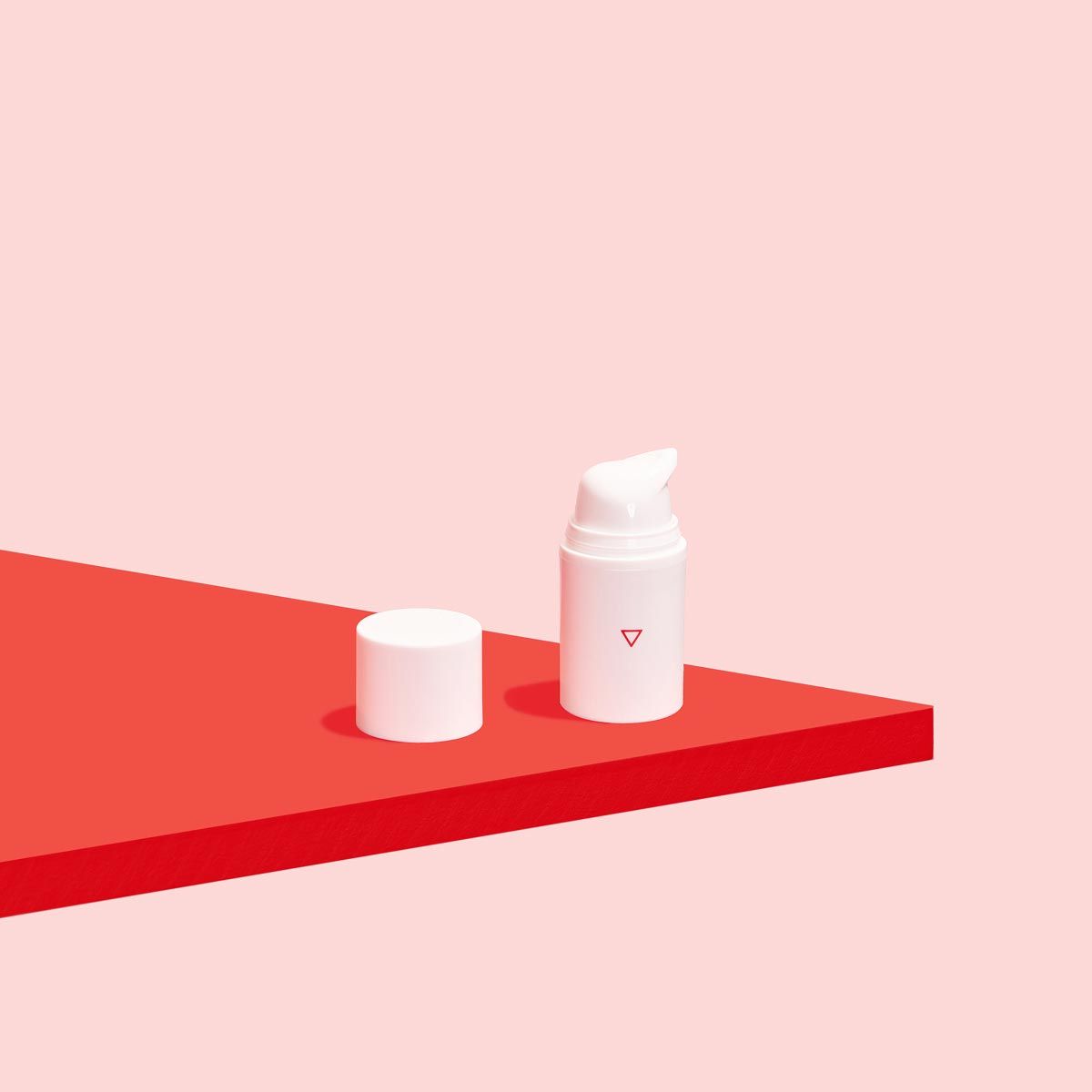 A Wisp pump bottle on a red surface with a pink background