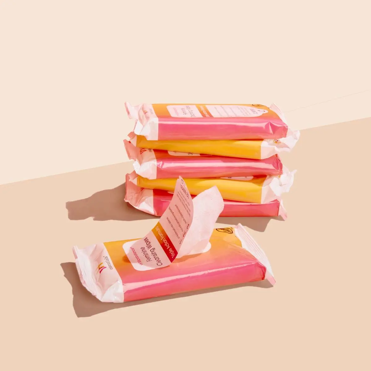 6 packages of pH Balancing Wipes on a cream surface with a red background